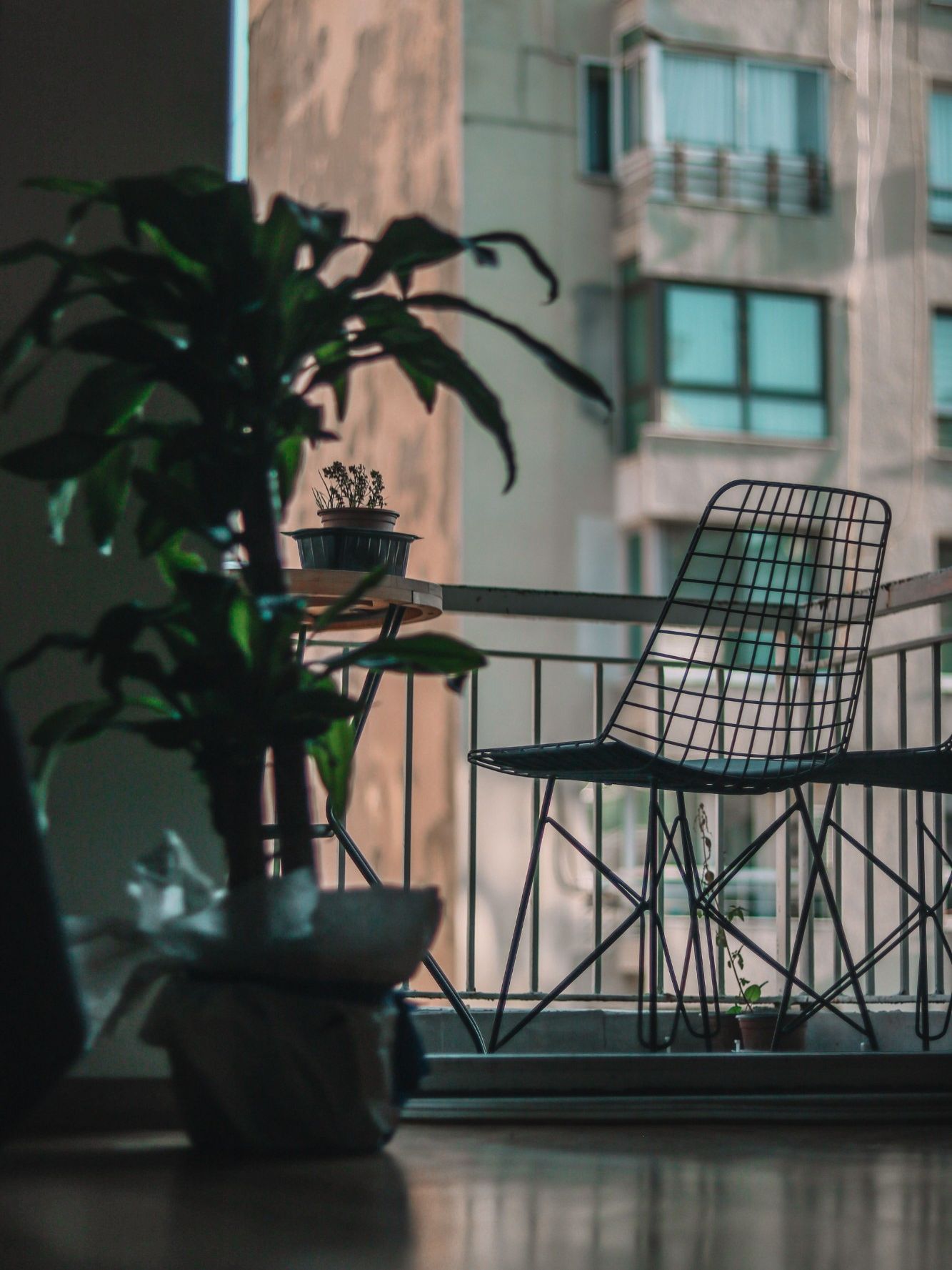 Illustrative balcony with a wire chair and potted plants
